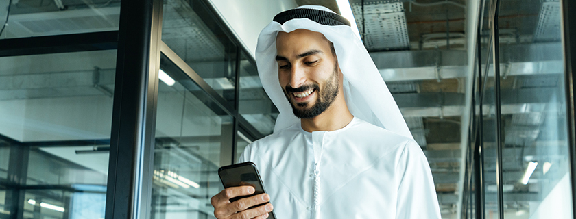Man using a smartphone in a Gulf business setting