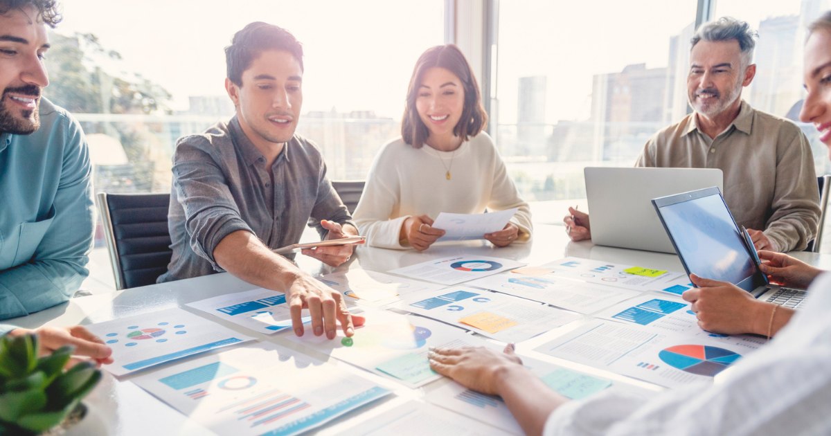 A design team reviewing printed page layouts together