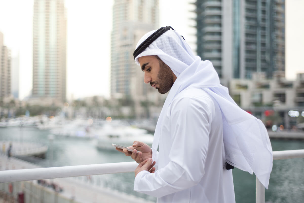 Arabic man in Dubai using social media on his phone